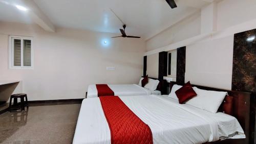 a bedroom with two beds and a ceiling fan at BYB Boutique Hotel in Thanjāvūr