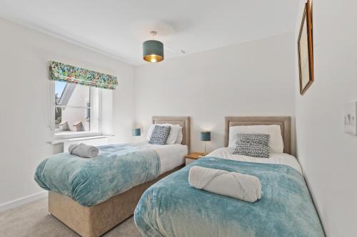 a bedroom with two beds and a window at The Old Workshop - North East Escapes in Wooler