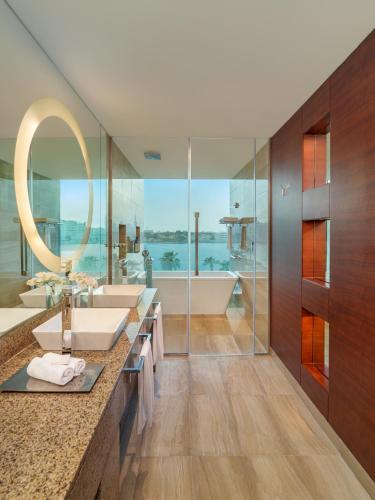 a bathroom with a sink and a tub and a mirror at Fairmont Bab Al Bahr in Abu Dhabi
