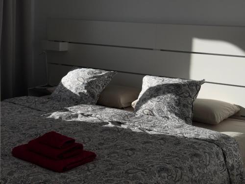 a bed with two pillows and a red towel on it at AMADORES BEACH VIEW APARTMENT in Amadores