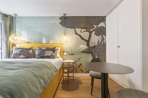 une chambre avec un lit et une table dedans dans l'établissement Petito, à Paris