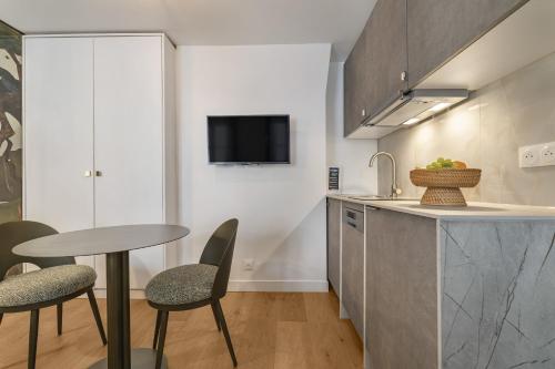 - une cuisine avec une table, 2 chaises et un évier dans l'établissement Petito, à Paris