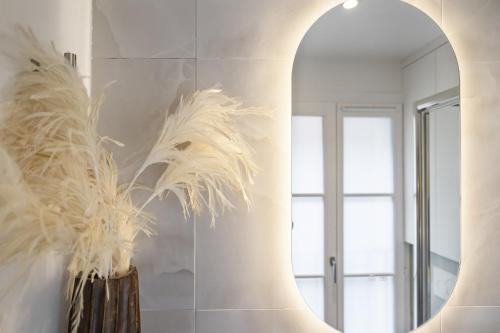 un couloir avec un miroir et un vase avec une plante dans l'établissement Petito, à Paris