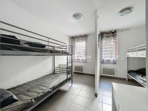 een kamer met 2 stapelbedden en 2 ramen bij 3313-Appartement 8 couchages avec piscine in Argelès-sur-Mer