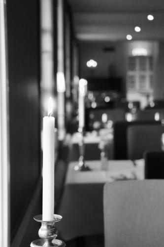 a candle sitting on a table in a restaurant at Åhus Gästgivaregård in Åhus