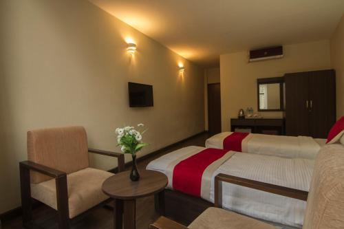 a hotel room with two beds and a chair at Hotel Regal Airport in Kathmandu