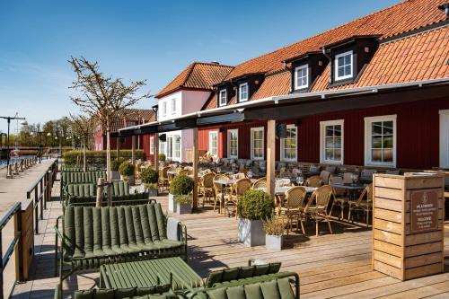 a row of chairs and tables on a wooden deck at Åhus Gästgivaregård in Åhus