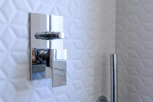ein Bad mit einem Metalllaucet an der Wand in der Unterkunft Appartamento - Brand New Luxury Apartment - Giardini Naxos, Recanati in Giardini-Naxos
