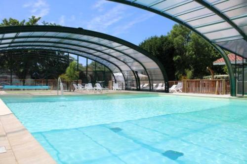 a large swimming pool with an arch over it at ZEcamping 4 étoiles chiens acceptés bien-être piscine couverte in Azur