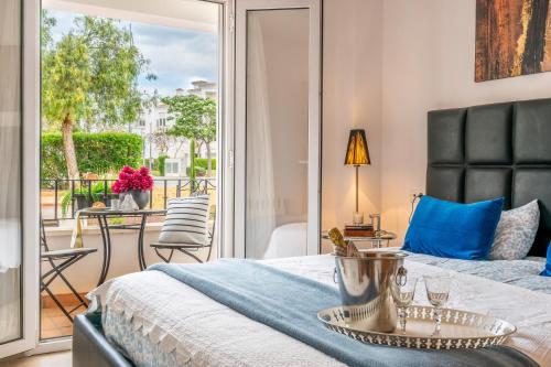 a bedroom with a king sized bed and a balcony at Atlantico - Golf And Sun Holiday in Murcia