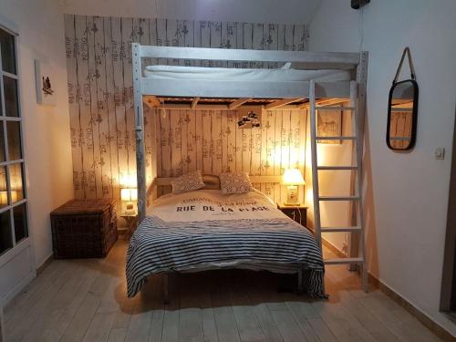 une chambre avec un lit superposé et une échelle dans l'établissement Les Lauriers Roses, à Noirmoutier-en-l'lle