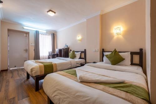 a hotel room with two beds in a room at Hotel Kathmandu Base Camp in Kathmandu