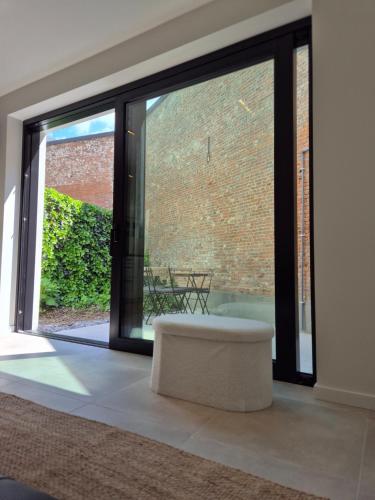a room with a large glass window with a bench at Huis ALNA 6 in Mechelen