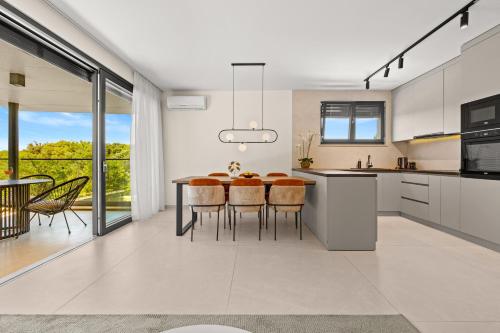a kitchen with a table with chairs and a dining room at Luxury Seaside Apartments Zadar in Zadar