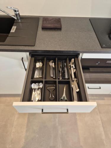 a drawer filled with utensils in a kitchen at Huis ALNA 6 in Mechelen