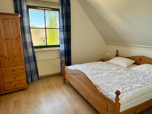 a bedroom with a bed and a window at Buitenplaats 105 in Callantsoog