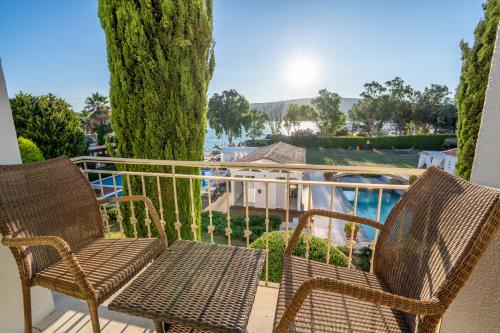 a balcony with two chairs and a view of a pool at Antmare Hotel in Alacati