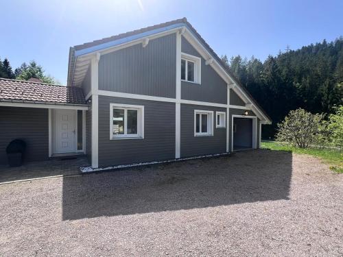 a house with a gravel driveway in front of it at Chalet Vertpheny Spa & Terrasse à 500m du Lac de Gérardmer in Gérardmer