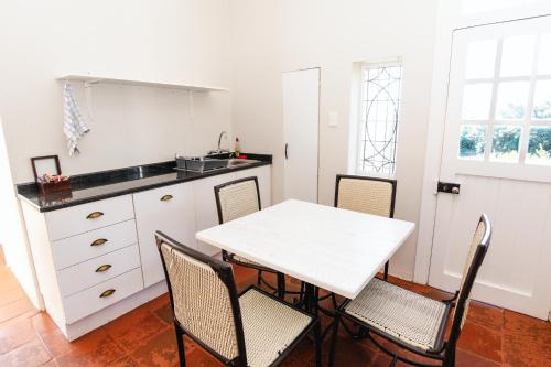 a kitchen with a white table and chairs at Botha House in Pennington