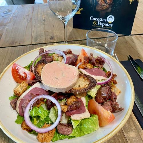 une assiette de salade avec de la viande et des légumes sur une table dans l'établissement ChezMaguy Gîte semi-rural vallée de l Isle Dordogne Périgord, à Montrem