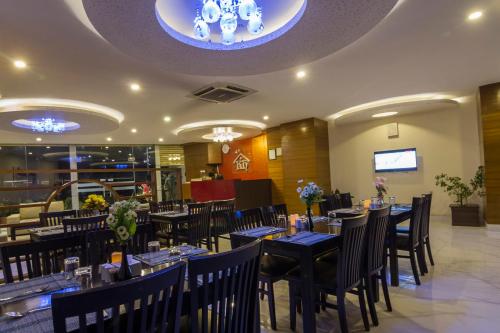 a restaurant with tables and chairs in a room at Hotel Regal Airport in Kathmandu