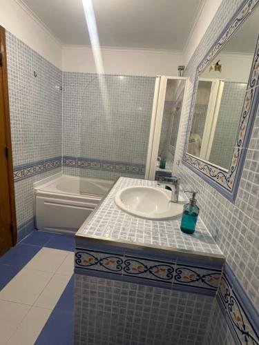 a bathroom with a sink and a mirror and a tub at Elegant Getaway II - Lisbon- 2 bedroom apartment in Montijo in Atalaia