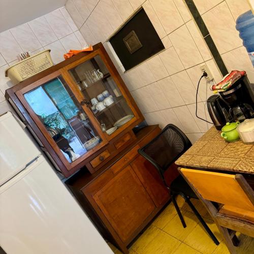 a kitchen with a wooden cabinet and a table at Habitación grande y confortable en el centro de la ciudad in Cochabamba