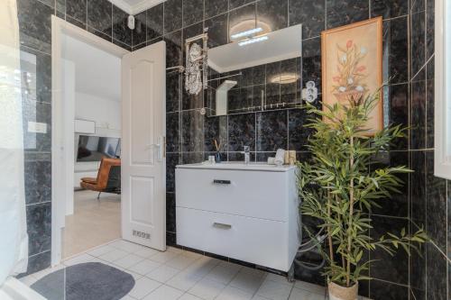 a bathroom with a white sink and a black tiled wall at Villa Blanca in Callao Salvaje