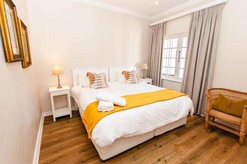 a bedroom with a large white bed and a chair at Botha House in Pennington
