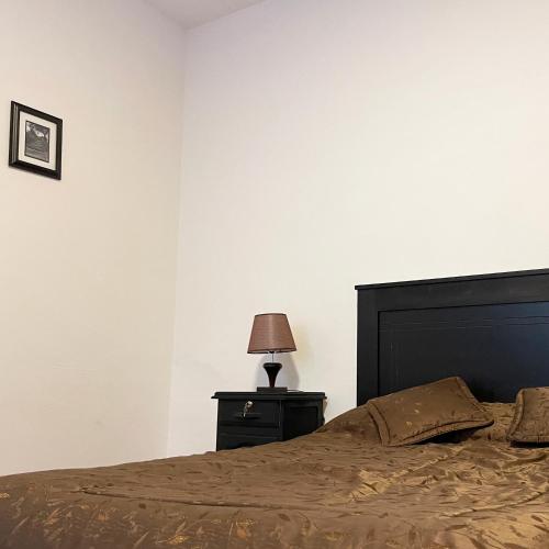a bedroom with a bed and a lamp on a nightstand at Habitación grande y confortable en el centro de la ciudad in Cochabamba