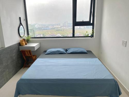 a bedroom with a bed and a large window at Nothingness House in Thôn Văn Dương