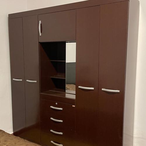 a large brown cabinet with a mirror at Habitación grande y confortable en el centro de la ciudad in Cochabamba