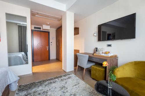 a hotel room with a bed and a desk and a television at Apollonia Hotel Gevgelija in Gevgelija