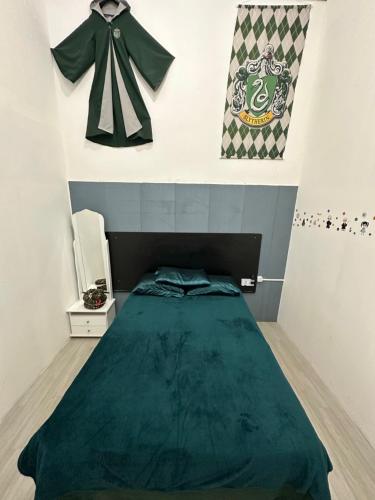a bedroom with a bed with a green blanket on the wall at Quarto Sonserina Nº 1 in Sao Paulo