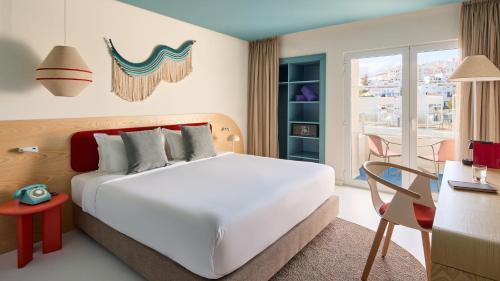 Un dormitorio con una cama grande blanca y un escritorio y un escritorio. en Hotel Indigo Albufeira by IHG, en Albufeira