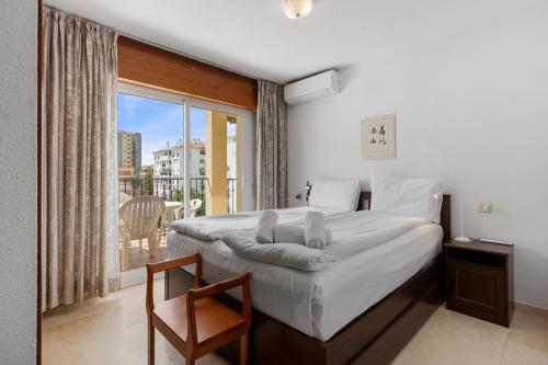 Un dormitorio con una cama grande y un balcón. en Apt ideal location by Costarentals - Ref 138, en Santa Fe de los Boliches