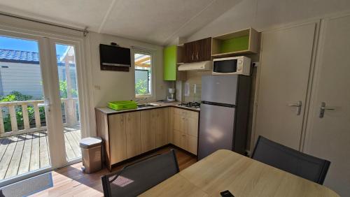 une cuisine avec une table et un réfrigérateur dans l'établissement Camping les Mancellieres, à Avrillé
