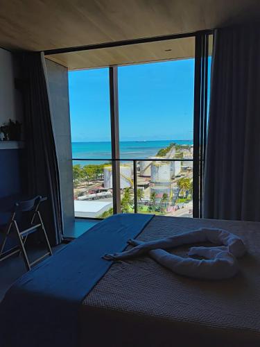 a bedroom with a bed with a view of the ocean at Edifício New Time Apto 1016 Pajuçara Maceió AL in Maceió