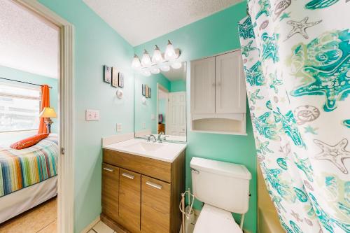 Un baño con inodoro, lavabo y cama. en Las Palmas 118 - The Sandy Palm, en Gulf Shores