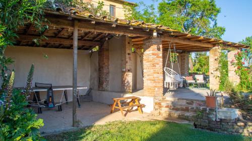 a patio with a wooden pergola and a table at Agriturismo La Ca'Solare in Palaia