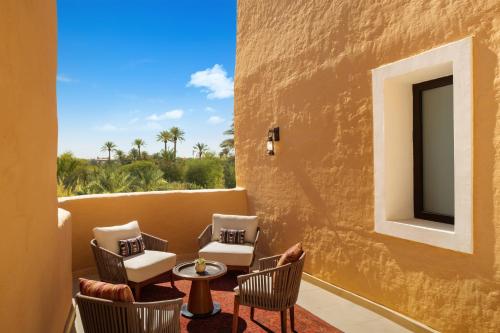 a balcony with chairs and a table and a tv at Bab Samhan, a Luxury Collection Hotel, Diriyah in Riyadh