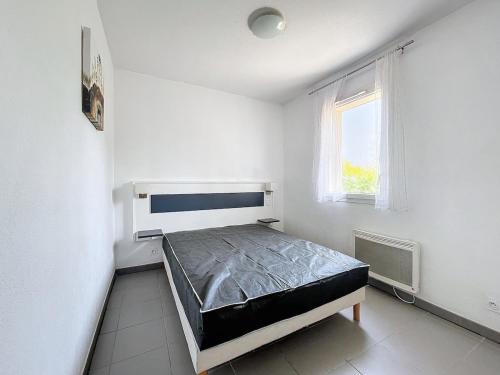 ein Schlafzimmer mit einem Bett in einem weißen Raum in der Unterkunft 3304-T3 dans une résidence avec piscine in Argelès-sur-Mer