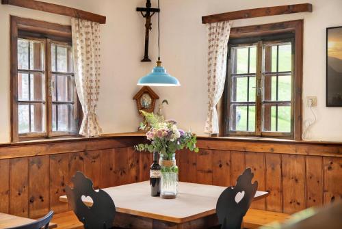 a table with chairs and a vase of flowers at Berghof Moosen in Hart im Zillertal