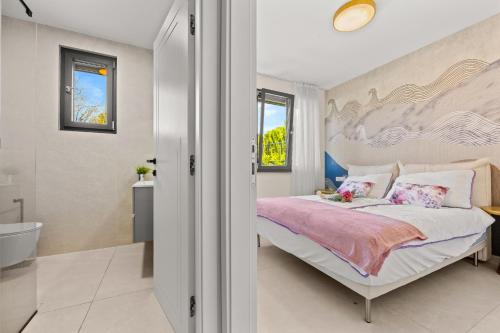 a bedroom with a large bed and a bathroom at Luxury Seaside Apartments Zadar in Zadar