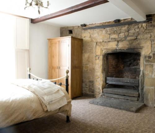 a bedroom with a stone fireplace and a bed at Cathedral View Guest House in Lincoln