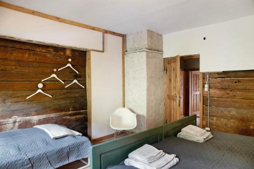 a bedroom with a bed and a wooden wall at Berghof Moosen in Hart im Zillertal