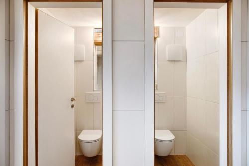 a bathroom with two toilets and a mirror at Berghof Moosen in Hart im Zillertal