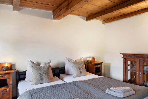 a bedroom with two beds and wooden ceilings at Berghof Moosen in Hart im Zillertal