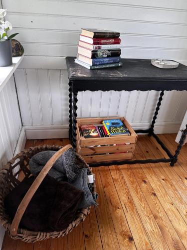 a table with books on it next to a basket at Trehornahult Lillstugan in Burseryd