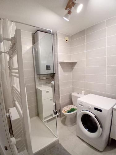 une salle de bain avec machine à laver et toilettes dans l'établissement La Pinède entre village et plage Saint Cyr sur Mer, à Saint-Cyr-sur-Mer